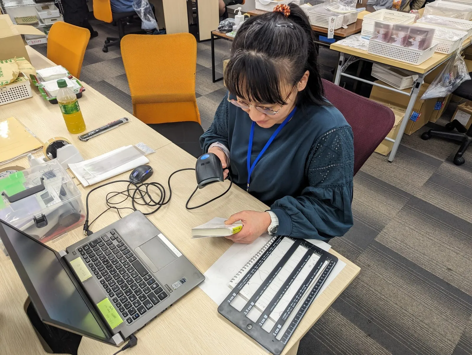 バーコードリーダーで本を読み取り、状態を確かめる様子