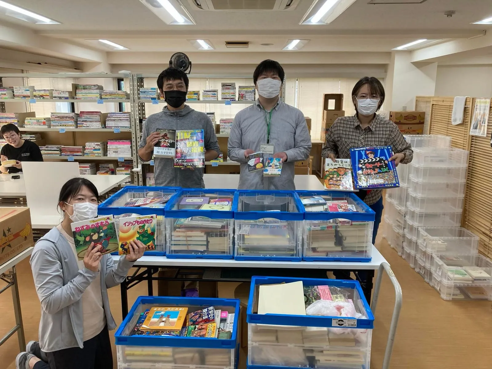 集められた本をコンテナに分け、施設のみなさんが本を手にしている様子